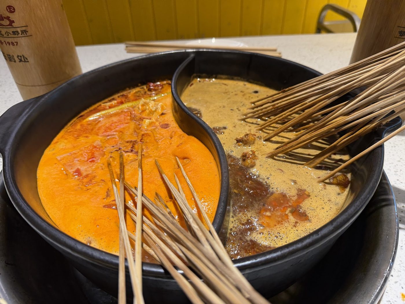 Spicy and non-spicy broth with bamboo skewers