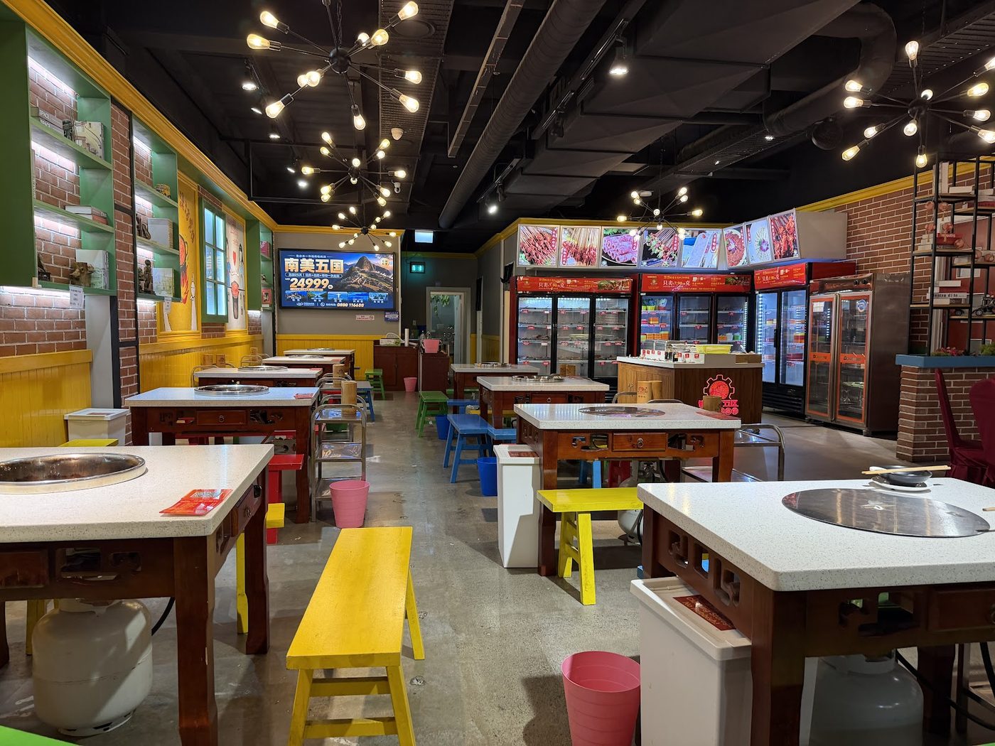Interior of XIAOJUNGAN with hot pot tables, colourful benches and warm lights
